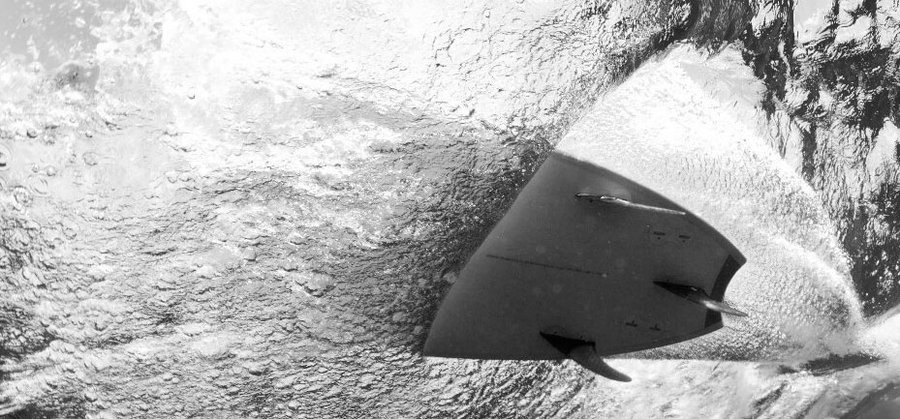 Underwater view of a board turning on the tail in a tube
